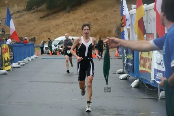 Erica Fox running towards a finish line, about to receive a medal.