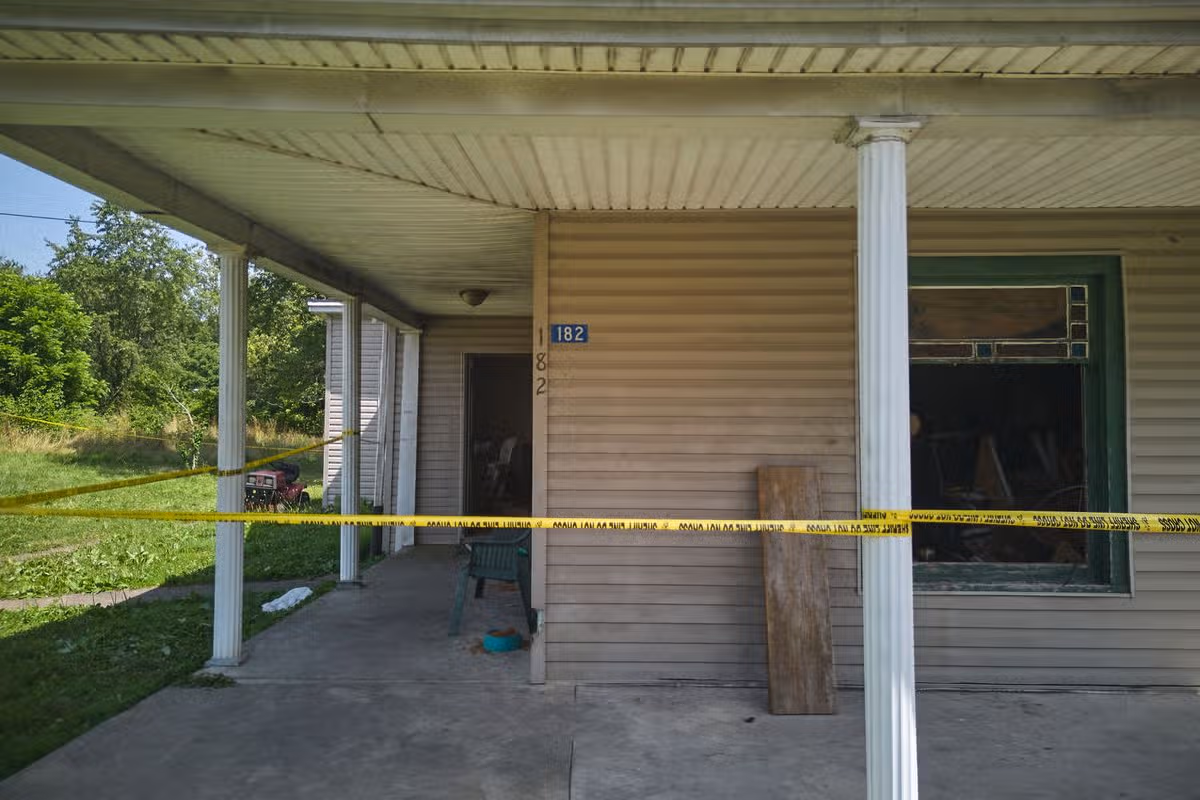 Police tape surrounds the front of a home where authorities say they removed 16 children and arrested four adults in Hamden, Ohio, Wednesday, July 1, 2026.