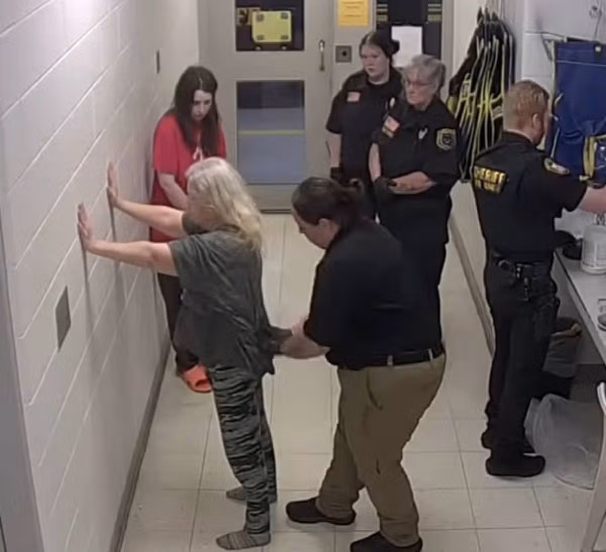Elizabeth Siders waits as mother-in-law Christina Siders is inspected by officers