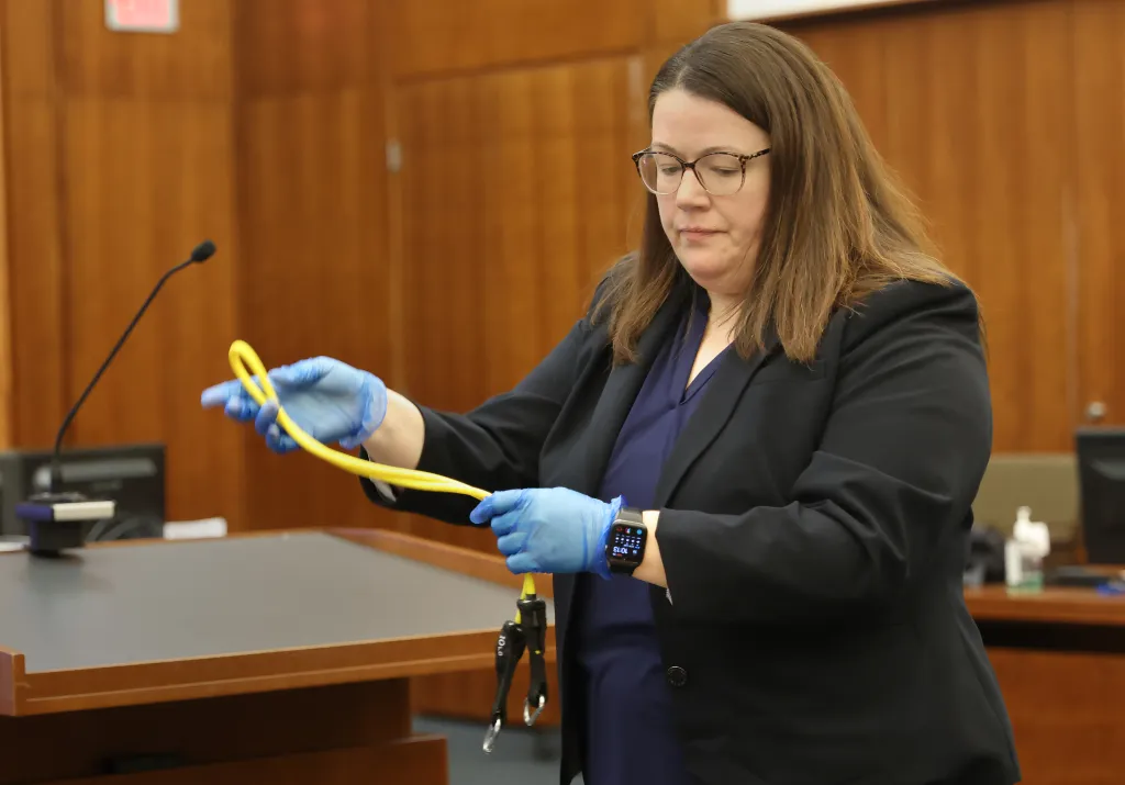 Assistant District Attorney Jennifer Sprague holding up a yellow exercise band.