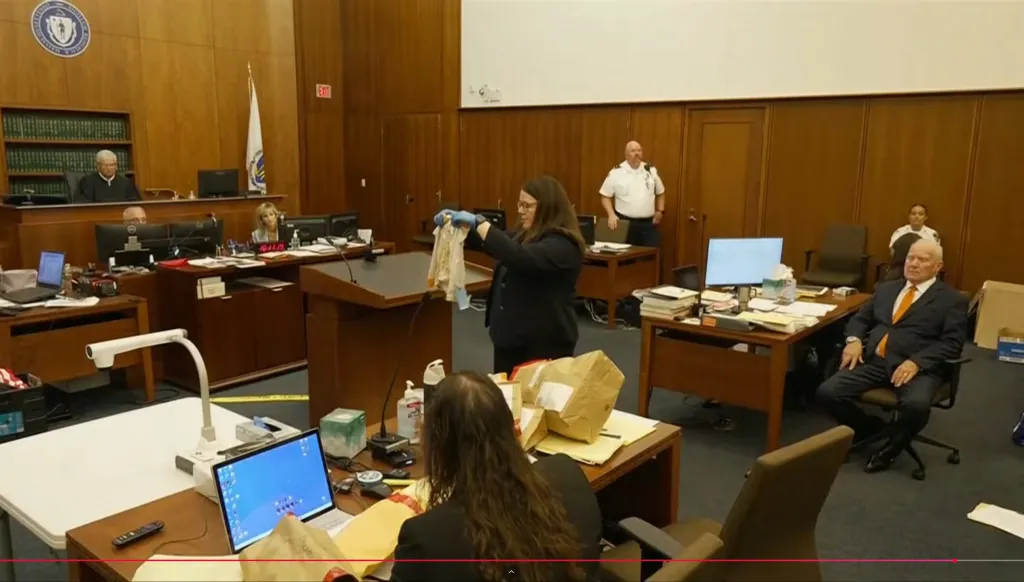 The prosecutor holds up children clothes one of the children were found in for the jury.