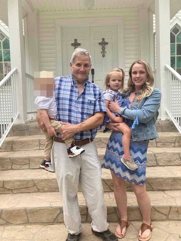 Geordyn Nichole Hayes, an older man, and two young children posing on steps in front of a white building with crosses on the doors.