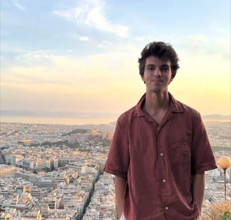 Christian Sosa, one of four people aboard a missing plane, stands against a city background at sunset.