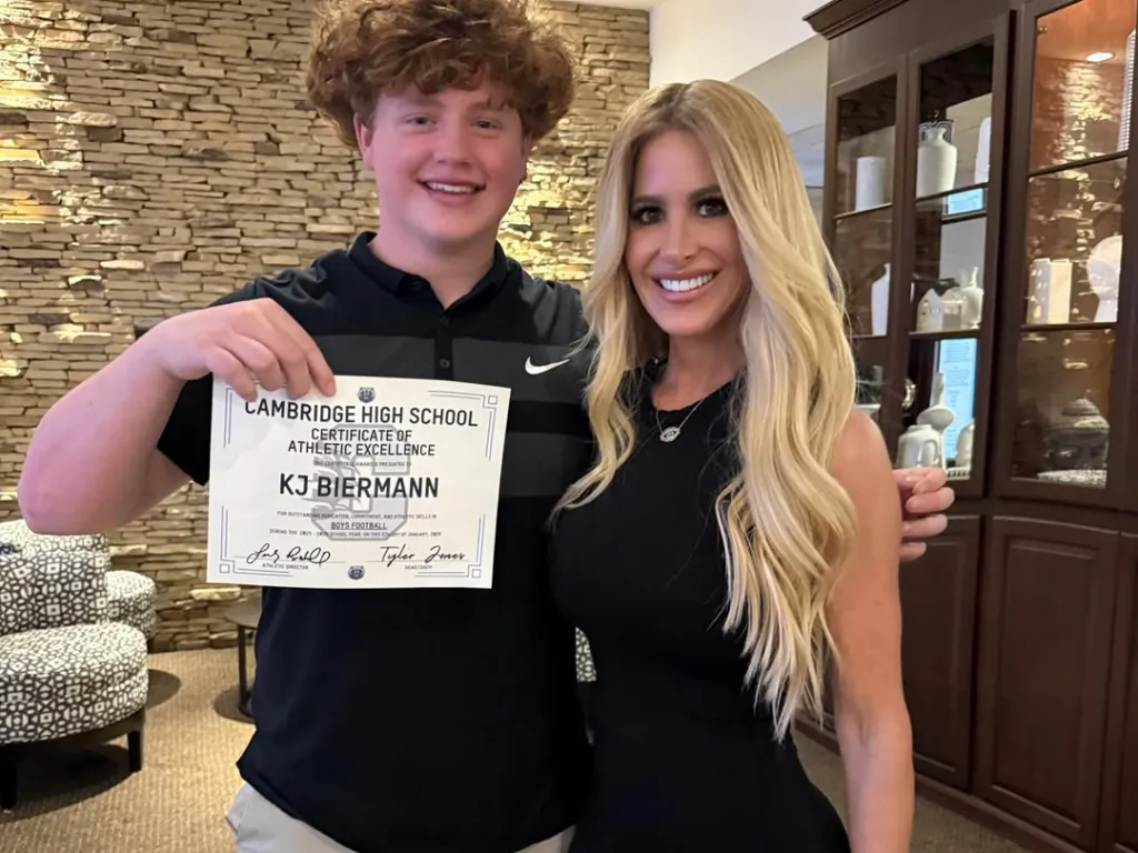 Kim Zolciak-Biermann and her son KJ Biermann, who is holding a "Certificate of Athletic Excellence" for boys' football.